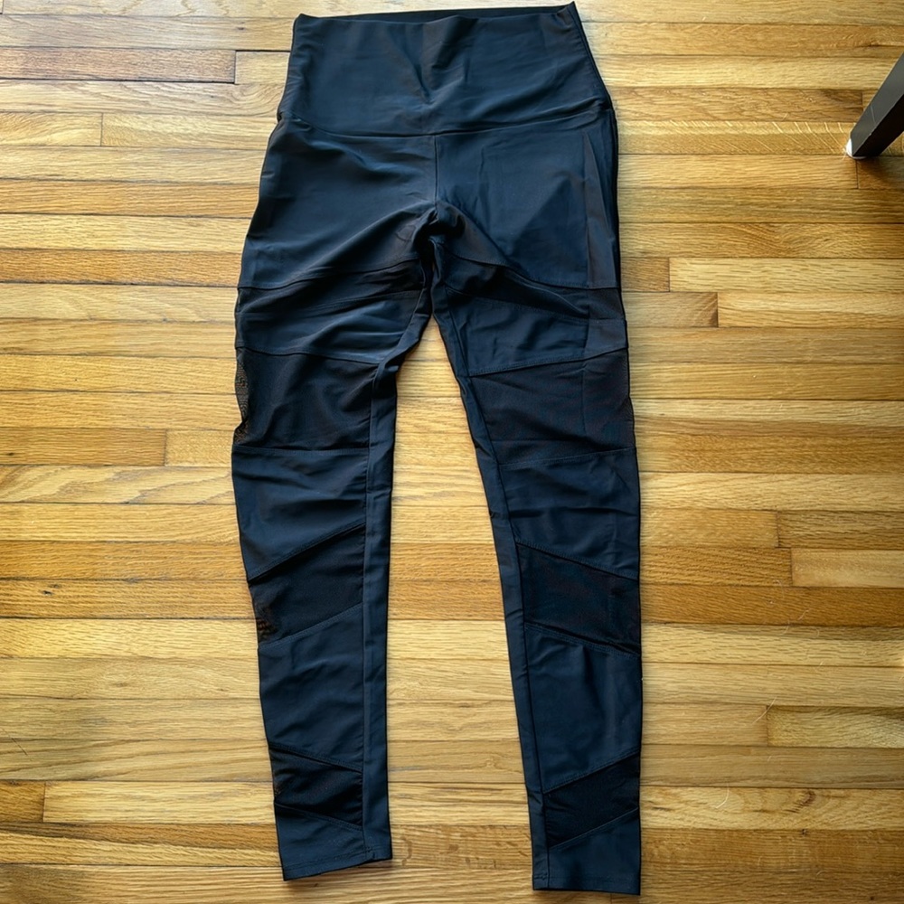 Onzie black leggings with 4 mesh parts in the front of each leg. Size M/L.